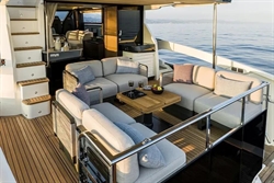 Luxurious 2025 Absolute 52 FLY yacht with elegant outdoor seating and ocean view.