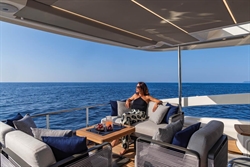 Luxury yacht Absolute 52 FLY 2025, woman relaxing on deck with ocean view.
