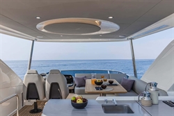 Luxurious 2025 Absolute 52 FLY yacht interior with ocean view and elegant dining setup.