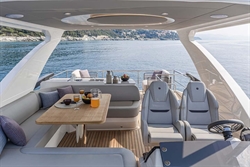 Luxurious 2025 Absolute 52 FLY yacht interior with dining area and ocean view.